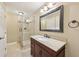 Bathroom with granite vanity, large mirror, and walk-in shower at 11180 West Rd, Roswell, GA 30075