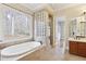Bright bathroom showcasing a large soaking tub next to a window with private wooded views at 11180 West Rd, Roswell, GA 30075