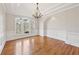 Formal dining room with wainscoting, chandelier, hardwood floors, and large windows at 11180 West Rd, Roswell, GA 30075