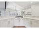 Bright, airy kitchen with white cabinets, hardwood floors, and a gas range in center island at 11180 West Rd, Roswell, GA 30075