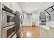 Bright kitchen with stainless appliances, light countertops, white cabinets, and hardwood floors throughout at 11180 West Rd, Roswell, GA 30075
