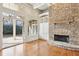 Well-lit living room with hardwood floors, a stone fireplace, built-in shelving, and french doors to outdoor patio at 11180 West Rd, Roswell, GA 30075