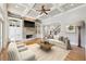 Bright living room featuring coffered ceilings, stone fireplace, built-in bookshelves, and hardwood floors at 11180 West Rd, Roswell, GA 30075