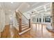 Spacious living room featuring hardwood floors, high ceilings, large windows, and staircase to the second floor at 11180 West Rd, Roswell, GA 30075