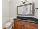 Traditional powder room with a granite vanity countertop and framed mirror at 11180 West Rd, Roswell, GA 30075