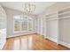 Large walk-in closet with hardwood flooring, custom shelving and natural light from a large arched window at 11180 West Rd, Roswell, GA 30075