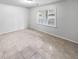 This bedroom features tile floors, a large window with outside view and neutral color scheme at 3783 Red Rose Ct, Loganville, GA 30052
