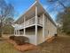 Exterior shot of the home showcasing covered deck, light siding, and a yard with pine straw at 3783 Red Rose Ct, Loganville, GA 30052