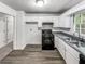 Well-lit kitchen featuring stainless steel sink, modern faucet, and matching black gas range at 3783 Red Rose Ct, Loganville, GA 30052
