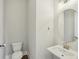 Powder room featuring a modern toilet, pedestal sink with an oval mirror, and updated fixtures at 264 Castleberry Station Sw Dr, Atlanta, GA 30313