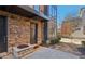 Brick townhome entrance featuring a covered porch, stone accent, and modern lighting at 264 Castleberry Station Sw Dr, Atlanta, GA 30313