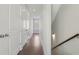 Hallway with hardwood floors, white trim, paneled doors, and a window at the end of the hall at 264 Castleberry Station Sw Dr, Atlanta, GA 30313