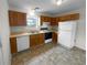 Functional kitchen with wood cabinets, standard appliances, and neutral flooring at 328 Village Ln, Stockbridge, GA 30281