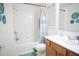 Bathroom featuring a shower-tub combo, decorative wall art and wood cabinets at 6674 Mimosa Cir, Tucker, GA 30084