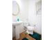 Half bathroom with pedestal sink, oval mirror, toilet and wood look floors at 6674 Mimosa Cir, Tucker, GA 30084