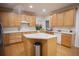 Spacious kitchen featuring wood cabinets, an island, wood flooring and stainless steel refrigerator at 6674 Mimosa Cir, Tucker, GA 30084