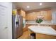 Well-lit kitchen with stainless steel refrigerator, wood cabinets, island and hardwood floor at 6674 Mimosa Cir, Tucker, GA 30084