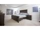 Spacious bedroom featuring neutral carpet, tray ceilings, a wooden bed frame, and abundant natural light at 6674 Mimosa Cir, Tucker, GA 30084