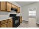 Galley kitchen with black appliances and wood look laminate flooring at 4878 Hairston Park Sq, Stone Mountain, GA 30083
