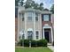 Two-story townhouse with a combination of brick and beige siding with trimmed windows and manicured landscaping at 8170 Oakley Cir, Union City, GA 30291