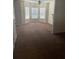 Spacious living room with carpet, three large windows, and a ceiling fan at 8170 Oakley Cir, Union City, GA 30291