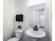 A neutral half bathroom featuring a pedestal sink and decorative mirror at 2163 Ben Hill Rd, Atlanta, GA 30344