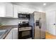Close-up of stainless steel appliances in a bright kitchen, featuring an oven, microwave, and refrigerator at 2163 Ben Hill Rd, Atlanta, GA 30344
