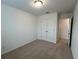 Neutral bedroom featuring plush carpeting, closet, and a sunlit window at 2105 Stillhaven Pl, Douglasville, GA 30135