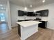 Bright kitchen with stainless steel appliances, dark cabinets, an island and modern pendant lighting at 2105 Stillhaven Pl, Douglasville, GA 30135
