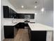 Modern kitchen with stainless steel appliances, dark cabinets, and island with white countertop at 2105 Stillhaven Pl, Douglasville, GA 30135
