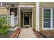 Inviting front porch featuring a wreath on the front door, covered entrance, and well-maintained landscaping at 5065 Avalon Dr, Alpharetta, GA 30005