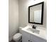 Modern half bathroom featuring white vanity with a black faucet and white toilet at 5459 Blossomwood Sw Trl, Mableton, GA 30126