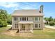 Rear view of a home with a covered porch and well-manicured lawn at 135 Waterlace Way, Fayetteville, GA 30215