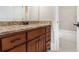 Bathroom boasts a granite vanity, dark wood cabinets, and view of a tiled shower-tub combo at 135 Waterlace Way, Fayetteville, GA 30215