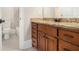Bathroom featuring granite vanity, wood cabinetry, and view of a shower-tub combo at 135 Waterlace Way, Fayetteville, GA 30215