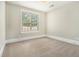 Bright bedroom features a window, neutral walls, and plush carpeting at 135 Waterlace Way, Fayetteville, GA 30215