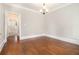 Empty room features neutral paint, a chandelier, and hardwood floors with decorative trim at 135 Waterlace Way, Fayetteville, GA 30215