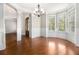Bright empty room with hardwood floors, wainscotting, and large windows overlooking trees at 135 Waterlace Way, Fayetteville, GA 30215