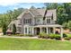 Charming two-story home with a covered porch, brick accents, and professionally landscaped front yard at 135 Waterlace Way, Fayetteville, GA 30215