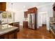 A spacious kitchen features stainless steel appliances, granite countertops and hardwood floors at 135 Waterlace Way, Fayetteville, GA 30215