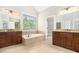 The main bathroom has separate vanities and a soaking tub under a window at 135 Waterlace Way, Fayetteville, GA 30215