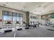 View of community gym with plenty of equipment; large windows providing natural light and views at 3040 Peachtree Nw Rd # 613, Atlanta, GA 30305