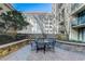 Community patio area with a table and seating, surrounded by lush landscaping and trees at 3040 Peachtree Nw Rd # 613, Atlanta, GA 30305