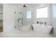 A luxurious bathroom with a soaking tub, a glass shower, and marble tiling at 4332 Kay Morgan Rd, Buford, GA 30519