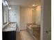 Bathroom featuring a double vanity, soaking tub, and glass-enclosed shower at 1080 Peachtree Ne St # 2915, Atlanta, GA 30309