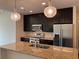 Modern kitchen with stainless steel appliances, granite countertops, stylish pendant lights, and dark wood cabinets at 1080 Peachtree Ne St # 2915, Atlanta, GA 30309