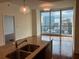 Open concept living space features a modern chandelier, wood floors, and large windows with city views at 1080 Peachtree Ne St # 2915, Atlanta, GA 30309