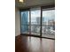Living room with wood floors and a large window offering views of the city skyline at 1080 Peachtree Ne St # 2915, Atlanta, GA 30309