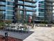Stylish outdoor seating area with a long table and green chairs with building reflection at 1080 Peachtree Ne St # 2915, Atlanta, GA 30309
