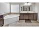 Bright bathroom featuring a soaking tub, shaker cabinets and a large window at 3890 Pleasant Woods Dr, Cumming, GA 30028